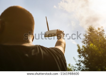 Man is looking for wi-fi signal in the nature. Guy is lost and holding router in his hands searching for internet connection. Modern technologies concept. Summer forest photo.