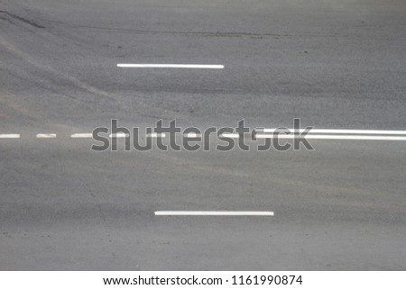 Asphalt road with white stripes. Dark gray urban asphalt road background texture