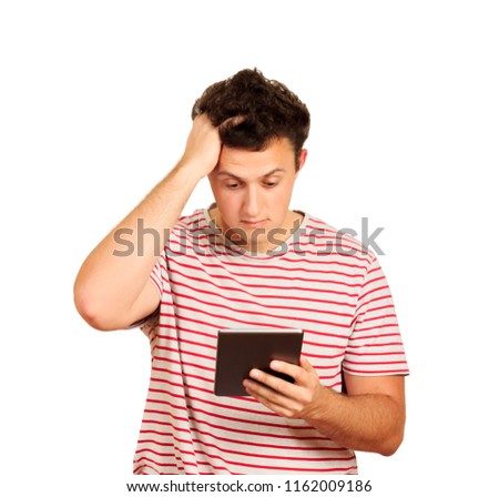 Young shocked student working on a digital tablet and holding on to head. emotional guy isolated on white background.