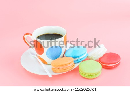 Close up of colorful cake macaroon or macaron isolated in vintage pastel colors tone on pink background with copy space. Sweet & colourful french macaroons with cup of black coffee. Small French cakes