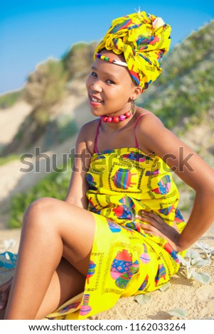 African beauty sitting on the beach looking at camera