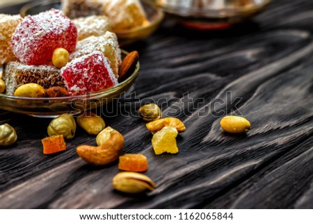 oriental sweets, lukum and nuts on a dark wooden background. Top view, copy space. Power Background