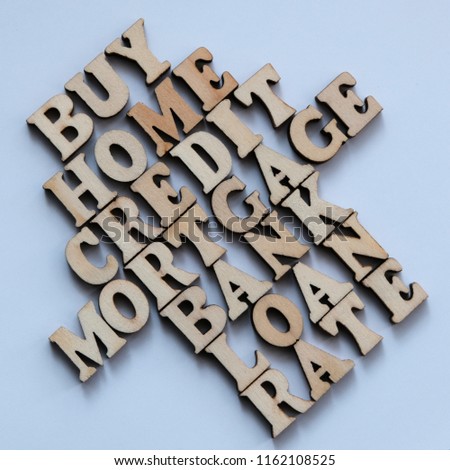 MORTGAGE, CREDIT, BANK and other words from wooden letters in the form of a house on a white background. A square picture. Theme of the loan and finance concept.