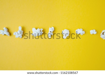 Popcorn in a Row on Yellow Background. Top View.