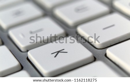 White letter K on a silver keyboard