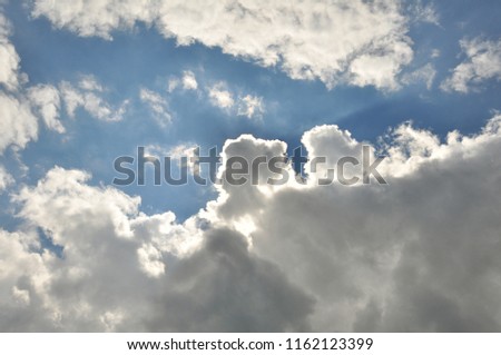 The sky with grey and white clouds on blue background.