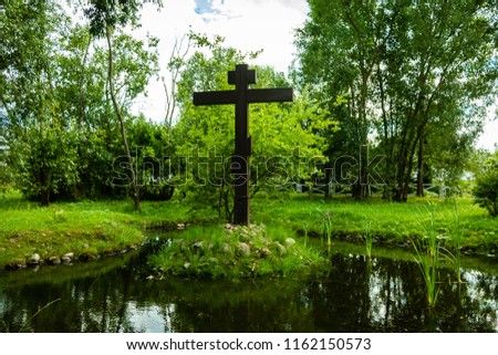 A wooden cross on an island in the middle of a lake