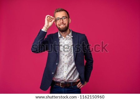 Portrait view of an attractive happy businessman with glasses on a pink background