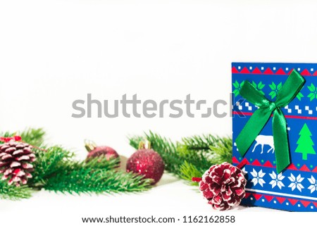 Fir branches on white decorated with christmas toys, gift box on white.