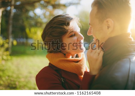 Close up of Young romantic couple smiling woman man in casual clothes embracing looking at each other on walk in autumn city park outdoors in sunny day. Love relationship family lifestyle concept Royalty-Free Stock Photo #1162165408