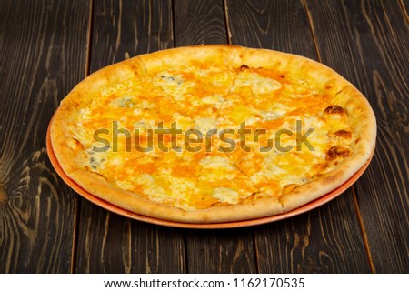 Pizza four cheeses over wooden background