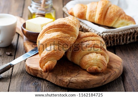 Delicious breakfast with fresh croissants and coffee served with butter and honey. Royalty-Free Stock Photo #1162184725