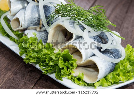 Fresh Herring Filet on a plate against wooden background