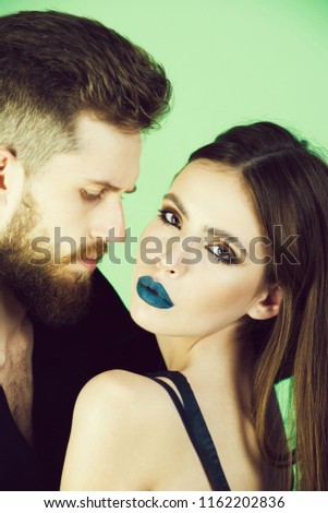 fashion couple in black, woman and man on green background, girl has long hair and fashionable makeup, guy has stylish beard