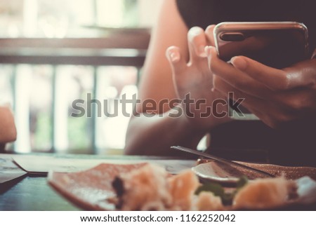 Woman hand using laptop and smartphone to work study with cafe shop colorful highlight shade to object beautiful background. Business, financial, trade stock maket and social network concept.