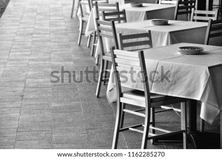 Tables wait for customers at an outdoor dining area.