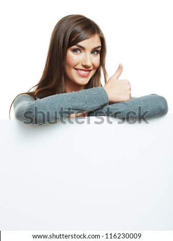 Smiling woman leaning on big blank board . Close up female face portrait with arms on blank card. Thumb up.