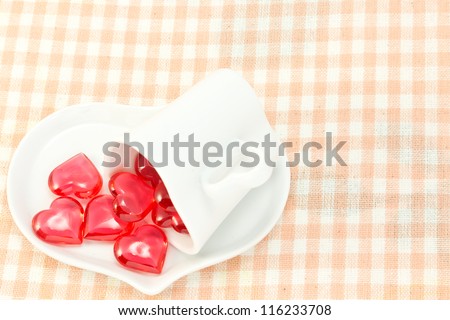 This is a picture of a red hearts and heart shaped cup on the table.