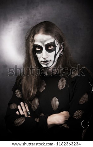 Portrait of man in goth style clothes with scull makeup.