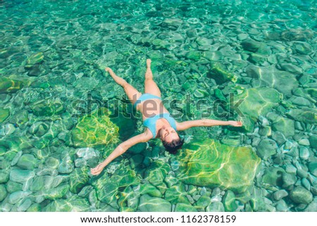woman swimming on back in clear blue sea water. summer vacation concept