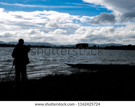 Male photographer at the river Take a sunset.