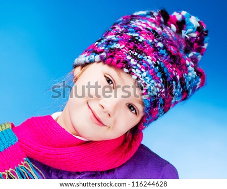 happy seven year old girl wearing a warm winter hat