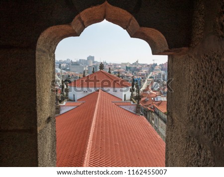 Scenic view of Porto, Portugal from the window of the tower. Orange roofs of the houses. Popular tourist destination. Travel photography.