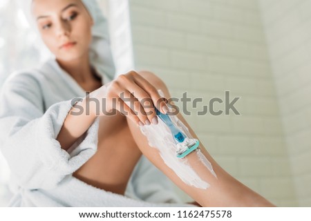 close-up view of young woman shaving leg in bathroom Royalty-Free Stock Photo #1162475578