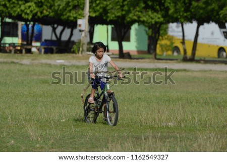 Girl teenager riding a bicycle on meadow 