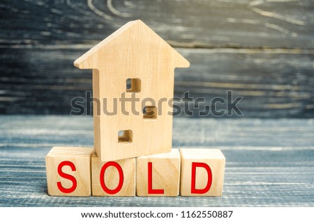 wooden house on a black background with the inscription sold. sale of property, home, real estate. affordable housing. place for text. copy space