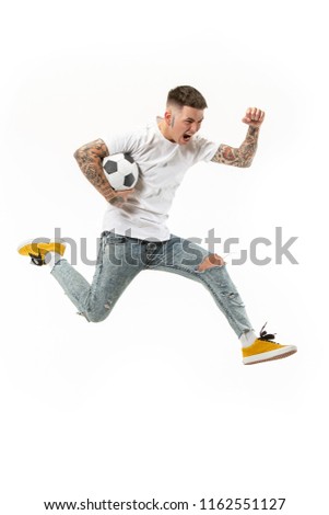 Forward to the victory.The young man as soccer football player jumping and kicking the ball at studio on a white background. Football fan and world championship concept. Human emotions concepts