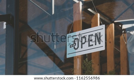 CU we are open sign hanging on the entrance door of a small cafe. Small business concept