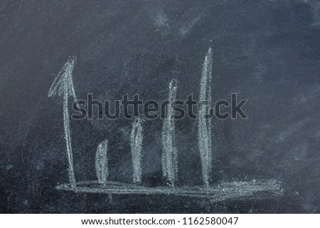 The graph shows the increase of the target. Dark board of space for copy. Draw chalk on a blackboard.