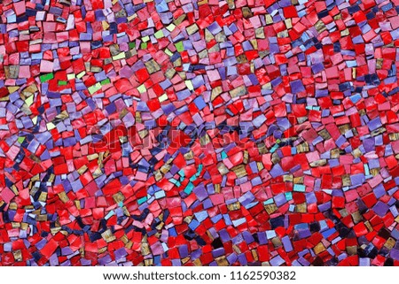 Colorful (red, pink, yellow, and purple) stone mosaic tiles on the wall as background or texture