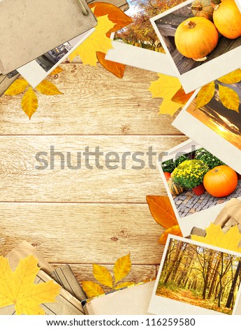 Frame with autumn leaves and photos. Objects over wooden planks