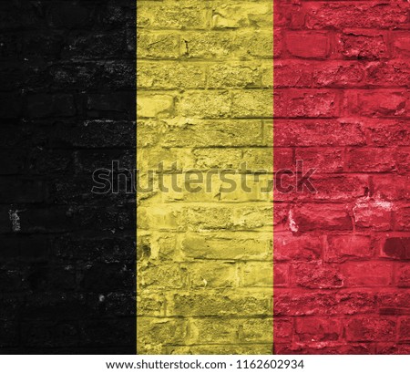 Flag of Belgium over an old brick wall background, surface