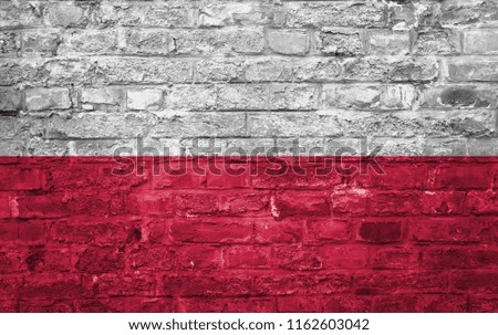 Flag of Poland over an old brick wall background, surface. White and red flag