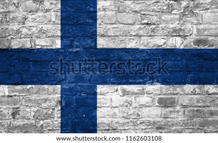 Flag of Finland over an old brick wall background, surface.