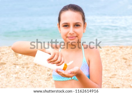 young teenager girl summer sea beach sunblock sunscreen cream