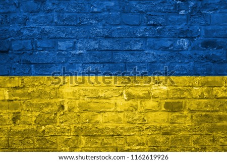 Flag of Ukraine over an old brick wall background, surface