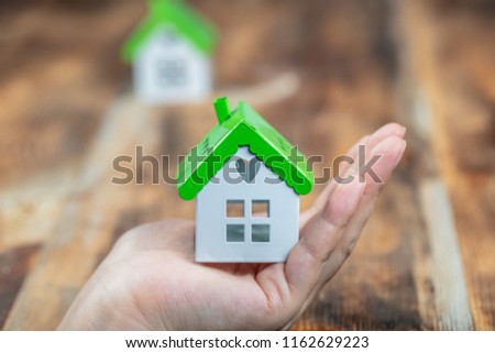 Real estate anda mortgage investment .being an easy way homeowner. The woman holds the house in the hand. Royalty-Free Stock Photo #1162629223