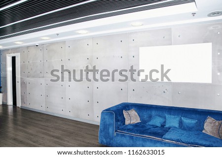 Trendy gray interior with blue sofa with blue and gray pillows in the reception office