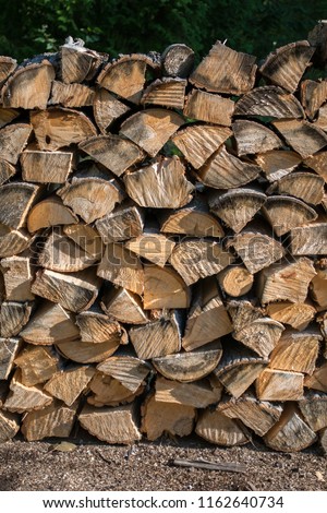 Cut split stacked firewood for winter background close-up in summertime while still golden