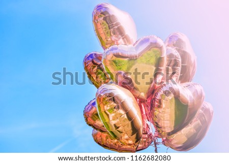 Bunch of Heart shaped ballons on the sky background, toned image