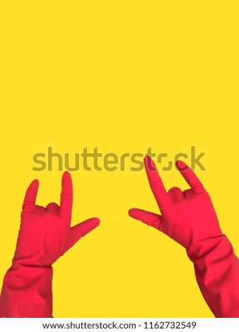 Hands in an economic glove of red color for household chemistry are isolated on colored backgrounds for a design
