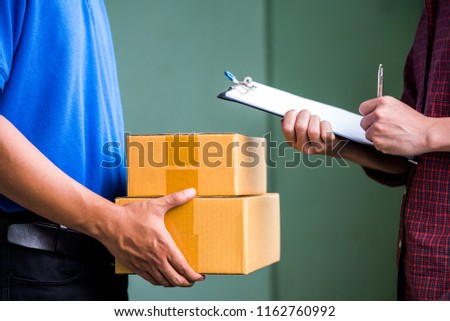 Close up man hands signing to get his package from delivery man.