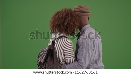 Black couple embracing and staring off into distance on green screen
