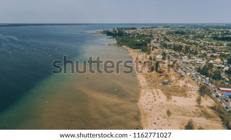 Aerial view of the beach. Transparent lake. People are sunbathing. Summer. Village. Houses. Ukraine.