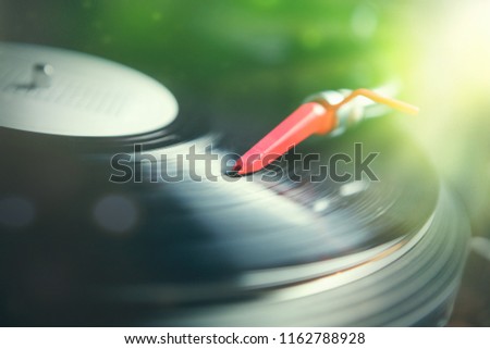 Turntables needle on vinyl record. DJ turn table playing hip hop music. Professional audio equipment for disc jockey. Retro audiophile records player with spherical needle cartridge