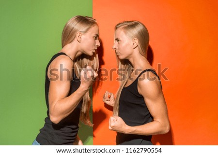 Angry women. Aggressive women standing isolated on trendy studio background. Female half-length portrait. Human emotions, facial expression concept. Front view.